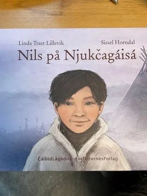 Omslag: "Nils på Njukcagáisá : basert på barndomsminner fortalt av Nils Reidar Utsi" av Linda Trast Lillevik